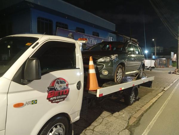 Guincho do Beto Auto Socorro à noite em rua de Joinville com carro em cima